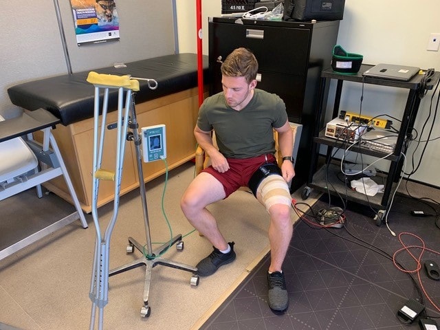 A study participant receiving blood flow restriction and electrical muscle stimulation to prevent muscle atrophy (photo courtesy of J. Burr)