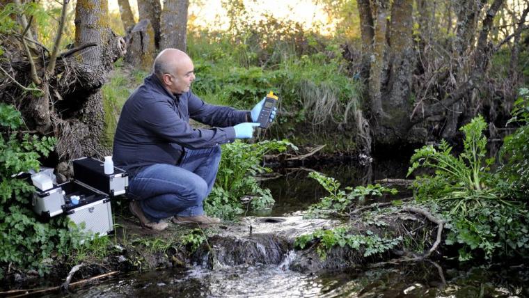 A biologist collects samples from a freshwater stream