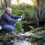 Researcher sampling microbes in freshwater